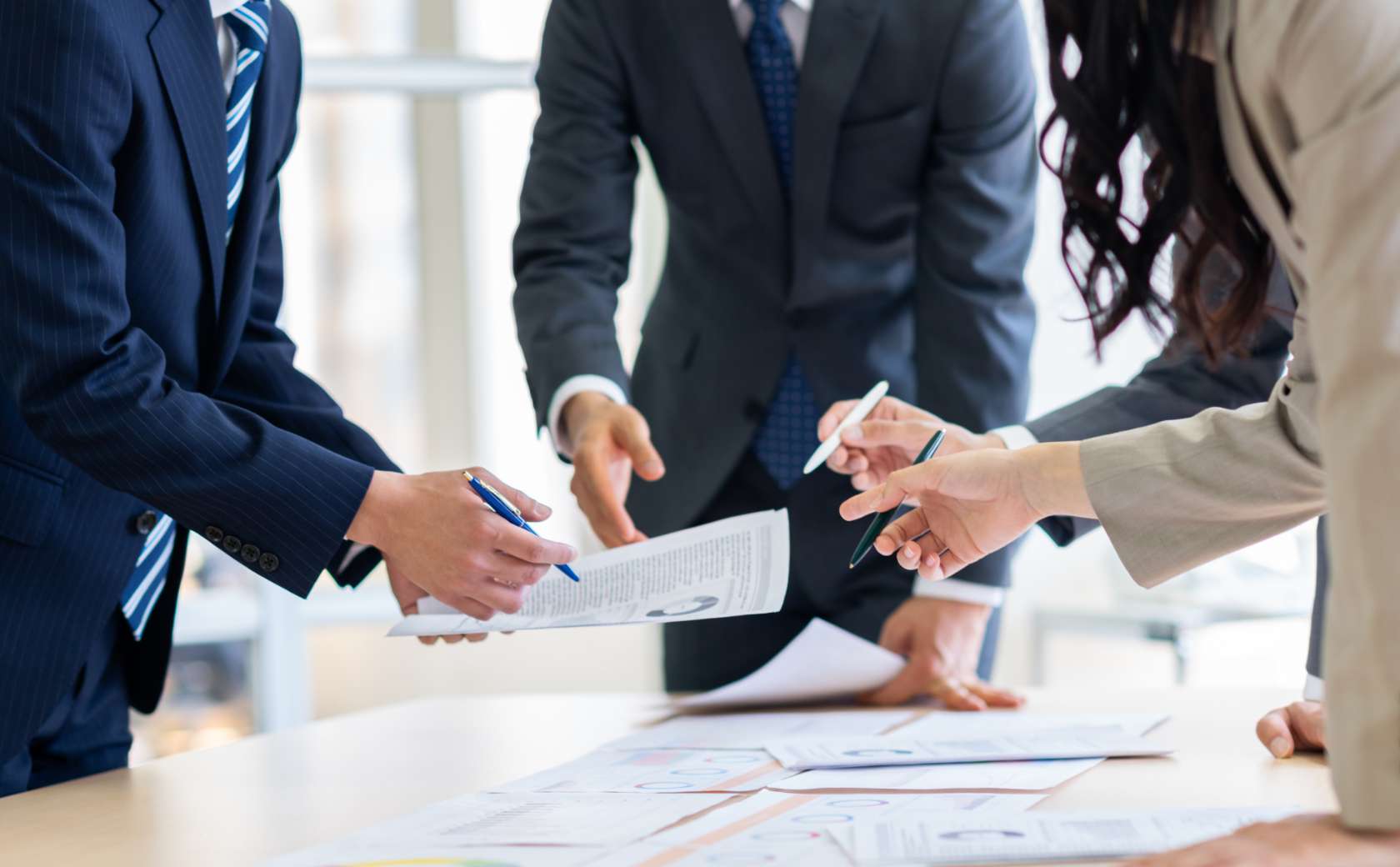 資料を手に会議する人のイメージ写真